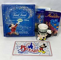 Lot overview with board game, two VHS tapes, Mickey mug, sealed license plate