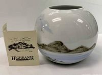 Front view of vase with maker booklet showing overall form and decoration