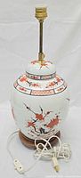 Full view of porcelain ginger jar lamp showing decoration, wood base, brass socket.