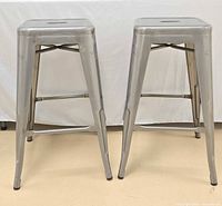 Two silver metal bar stools front view