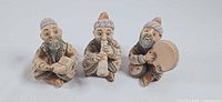 Front view of all three seated musician figurines