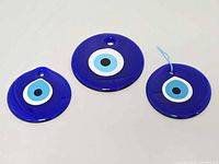 Three glass evil eye amulets side by side