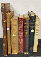 Spines of all seven poetry books showing titles, authors and decorative cloth