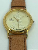 Close-up of watch face showing Mickey Mouse design, Lorus branding and gold tone case