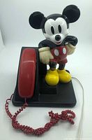 Front view of Mickey Mouse telephone showing handset, coiled cord, and full figure