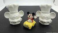 Front view of two white Chef Mickey shakers and one Mickey in yellow car shaker