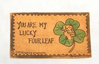 Front of leather postcard showing clover artwork and title