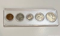Obverse side of five coins in acrylic holder