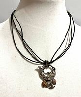 Full view of necklace on bust showing fish pendant and cord