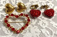 Brooch and both earring pairs grouped on lace background