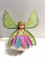 Front view of Riley doll wearing fairy outfit on stand