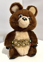 Front view showing plush bear, Olympic rings belt, facial features