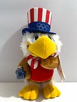 Front view of Sam the Olympic Eagle plush with hang tag visible