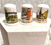 Front view of three thimbles showing Windermere, Yeoman Warder, Coventry Cathedral designs