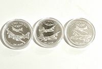 Group shot of three aviation tokens in capsules showing reverse aircraft designs
