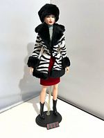 Front view of doll in full outfit on stand