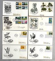 Front view of eight first day cover envelopes displaying cachets and stamps