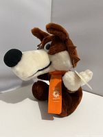 Front view of plush Vučko showing face and necktie with logo