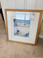 Full view of framed artwork leaning against wall