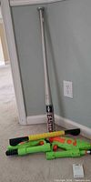 Full view of bat, SKLZ bar and two Super Soakers on floor