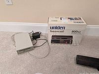 Boxed Uniden Bearcat 800XLT scanner next to Signal Cable Receiver Plus device and power adapter