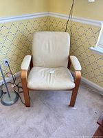 Front view of cream upholstered armchair with wood frame