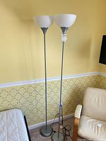 Full view of both matching floor lamps beside furniture