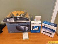 Group shot of Gear VR box with gaming headset on top, WD Blue SSD box, WiFi endoscope box