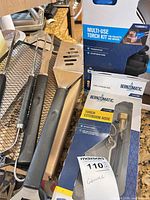 Torch kit, hose, grill tools and mesh tray on counter