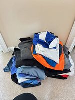 Pile of assorted men’s shirts in various colors and styles