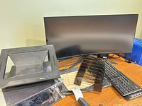 Curved monitor, keyboards, riser stands, file sorter visible