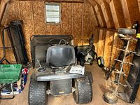Overall view inside shed showing tractor, cart, tiller, spreader and aerator