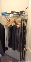 Dress pants on hangers with belts hanging beside