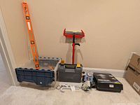 Overall lot showing level, roller stand, toolbox, tote, boxed shower head