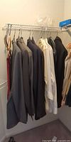 Suits and shirts hanging on wire rack