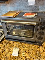 Front view of Tovala oven on countertop with manuals on top