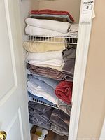 Four wire shelves filled with stacked towels, various colors and sizes