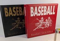 Front view of red and black baseball card binders