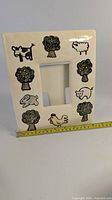 front of ceramic picture frame showing farm animal decorations and photo opening