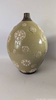 Full view of green crackle glaze vase with floral motifs