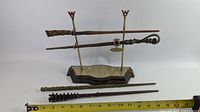 Full view of four wands and display stand with measuring tape for scale