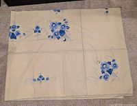 Full view of folded tablecloth showing overall embroidery layout