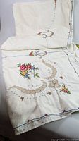 Folded tablecloth showing floral embroidery and cutwork detail