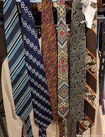 Six ties hanging on rack showing full patterns