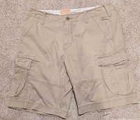 Front view of khaki cargo shorts with pockets and waistband detail