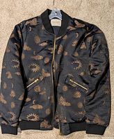 Full view of front of bomber jacket showing pattern, zipper and pockets