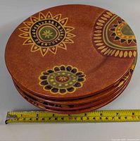 Stack of four Rio pattern plates with tape measure showing diameter