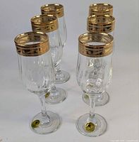 Six gold-rimmed wine glasses front view