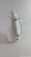 Full view of white ribbed thermal carafe with lid and handle