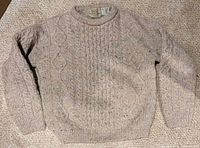 Front view of natural flecked cable-knit wool sweater